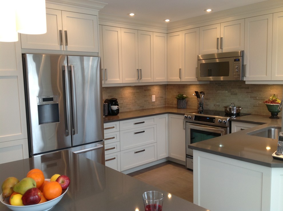 Enclosed kitchen - contemporary u-shaped enclosed kitchen idea in Montreal with a single-bowl sink, shaker cabinets, white cabinets, quartz countertops, beige backsplash, stone tile backsplash and stainless steel appliances
