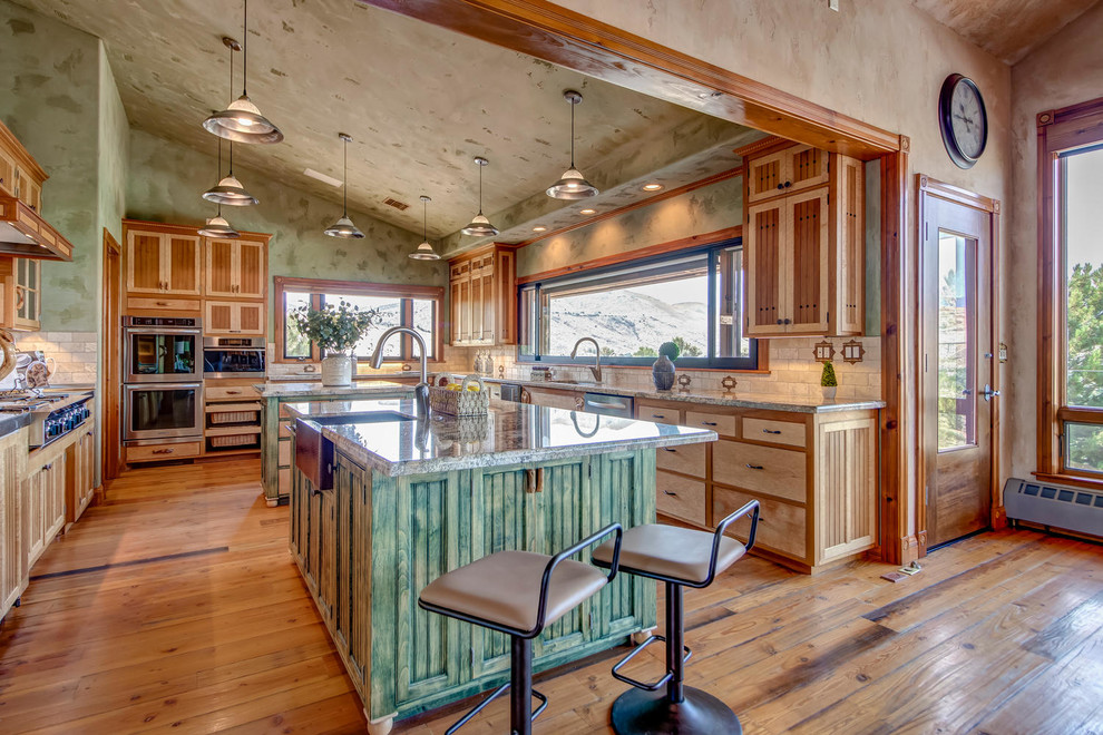 Southwest u-shaped light wood floor kitchen photo in Other with a farmhouse sink, shaker cabinets, light wood cabinets, stone tile backsplash, stainless steel appliances and two islands