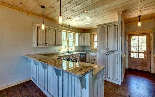 This is an example of a large rustic u-shaped open plan kitchen in Atlanta with a submerged sink, louvered cabinets, white cabinets, granite worktops, white splashback, stainless steel appliances, medium hardwood flooring and a breakfast bar.