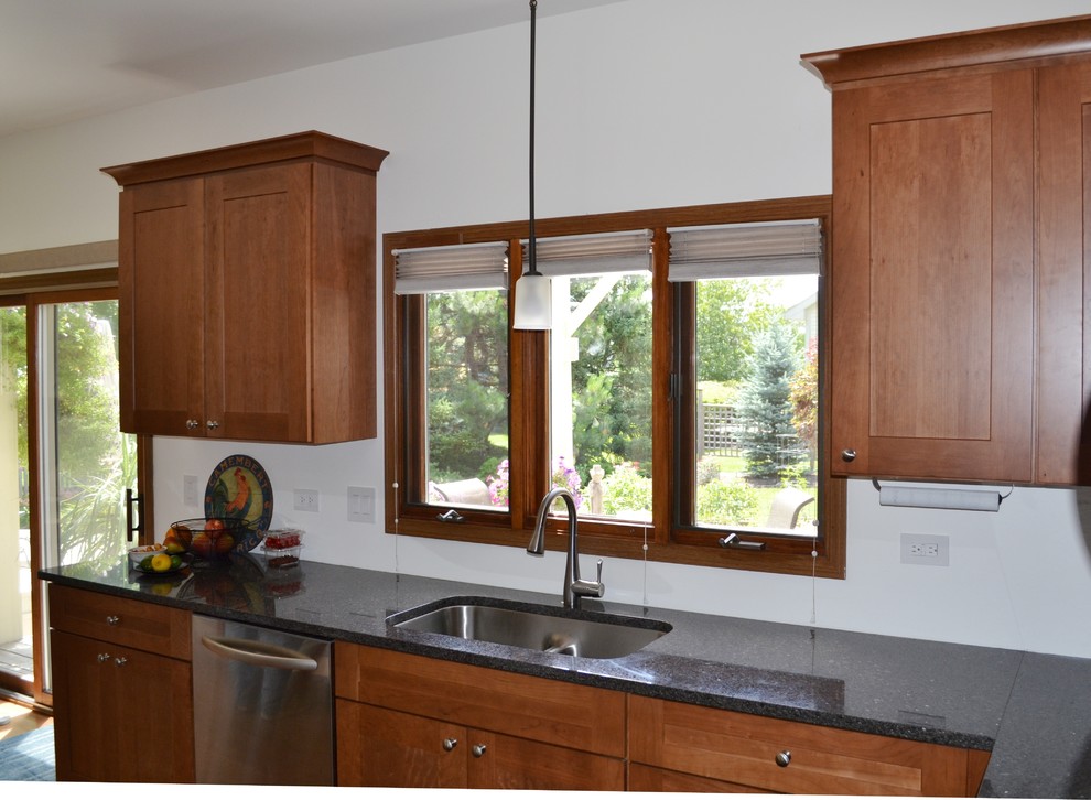 Idée de décoration pour une cuisine tradition en bois brun avec un placard à porte shaker et un plan de travail en granite.