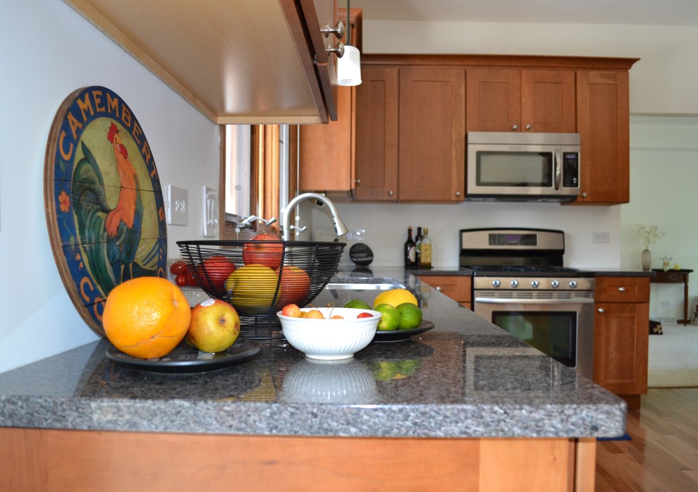 Exemple d'une cuisine chic en bois brun avec un placard à porte shaker et un plan de travail en granite.