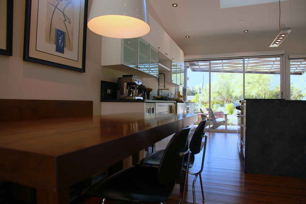 Modelo de cocina comedor contemporánea de tamaño medio con armarios tipo vitrina, puertas de armario blancas, electrodomésticos de acero inoxidable y una isla