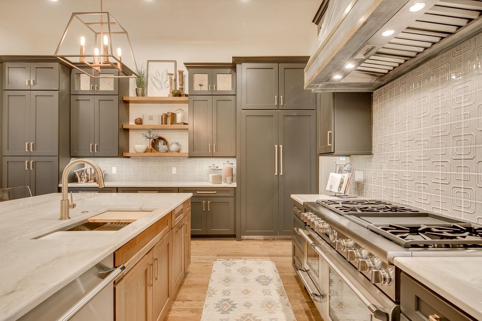 Inspiration for a large transitional l-shaped medium tone wood floor and brown floor open concept kitchen remodel in Other with an undermount sink, shaker cabinets, gray cabinets, gray backsplash, an island, marble countertops, porcelain backsplash and paneled appliances