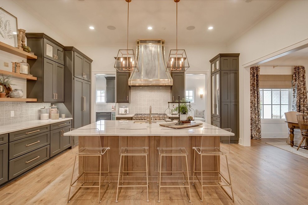Inspiration for a large cottage single-wall medium tone wood floor and brown floor open concept kitchen remodel in Other with shaker cabinets, gray cabinets, marble countertops, an island, gray backsplash, an undermount sink, porcelain backsplash and paneled appliances