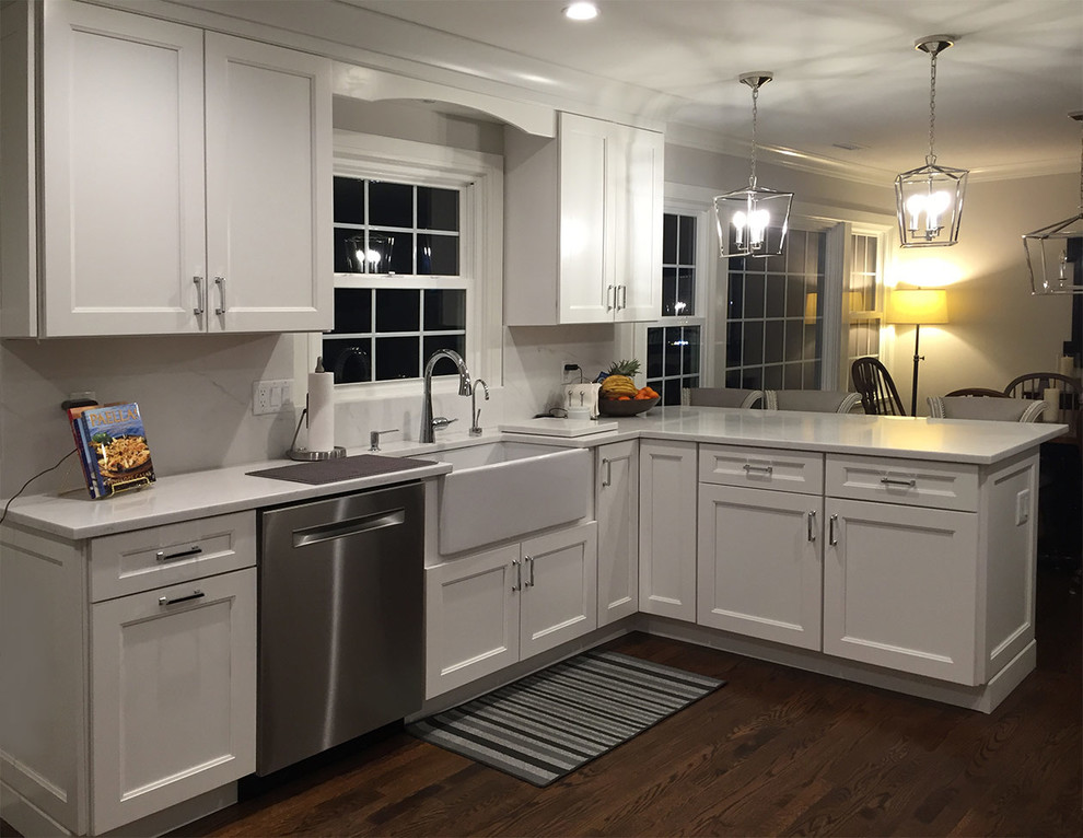 Klassische Küche mit Schrankfronten mit vertiefter Füllung, weißen Schränken, Küchengeräten aus Edelstahl und dunklem Holzboden in New York