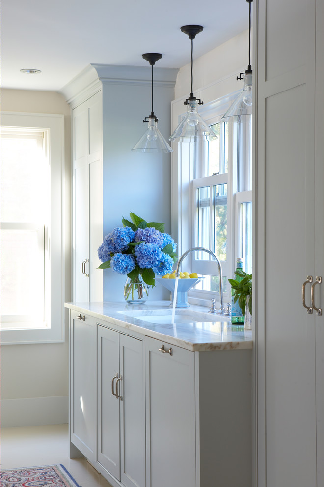 Mid-sized transitional galley porcelain tile and beige floor enclosed kitchen photo in Boston with an undermount sink, shaker cabinets, white cabinets, quartzite countertops, paneled appliances and no island