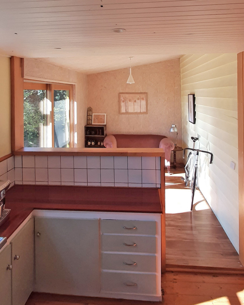 他の地域にある低価格の小さなカントリー風のおしゃれなキッチン (木材カウンター、白いキッチンパネル、セラミックタイルのキッチンパネル、板張り天井) の写真