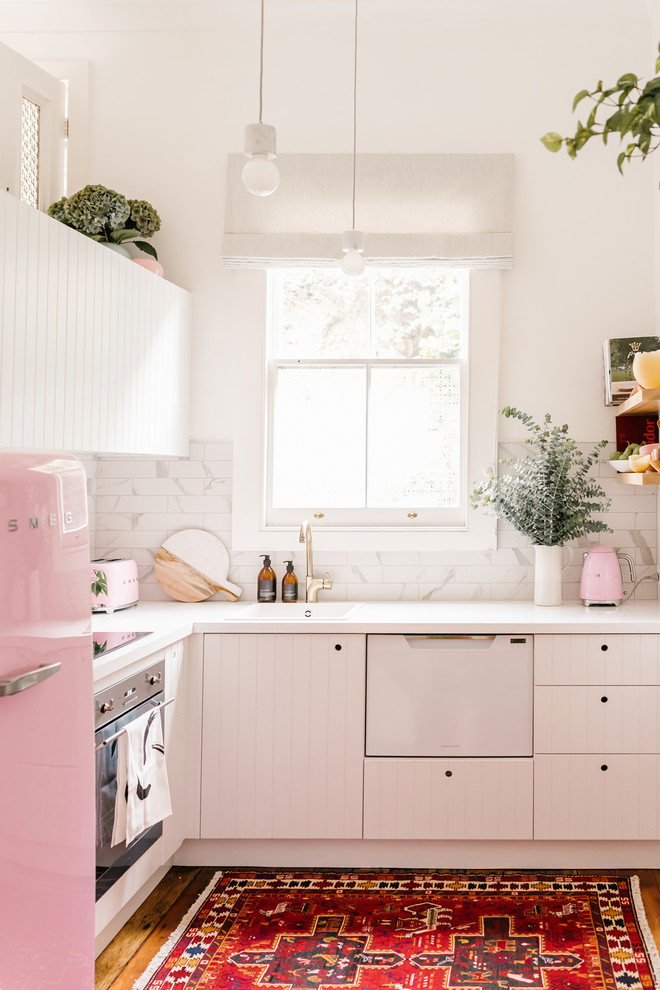 Small eclectic l-shaped enclosed kitchen photo in Napier-Hastings with a drop-in sink, white cabinets, laminate countertops, white backsplash, marble backsplash, white appliances and no island