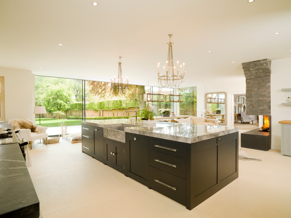 Contemporary open plan kitchen in Oxfordshire with a belfast sink, shaker cabinets and dark wood cabinets.