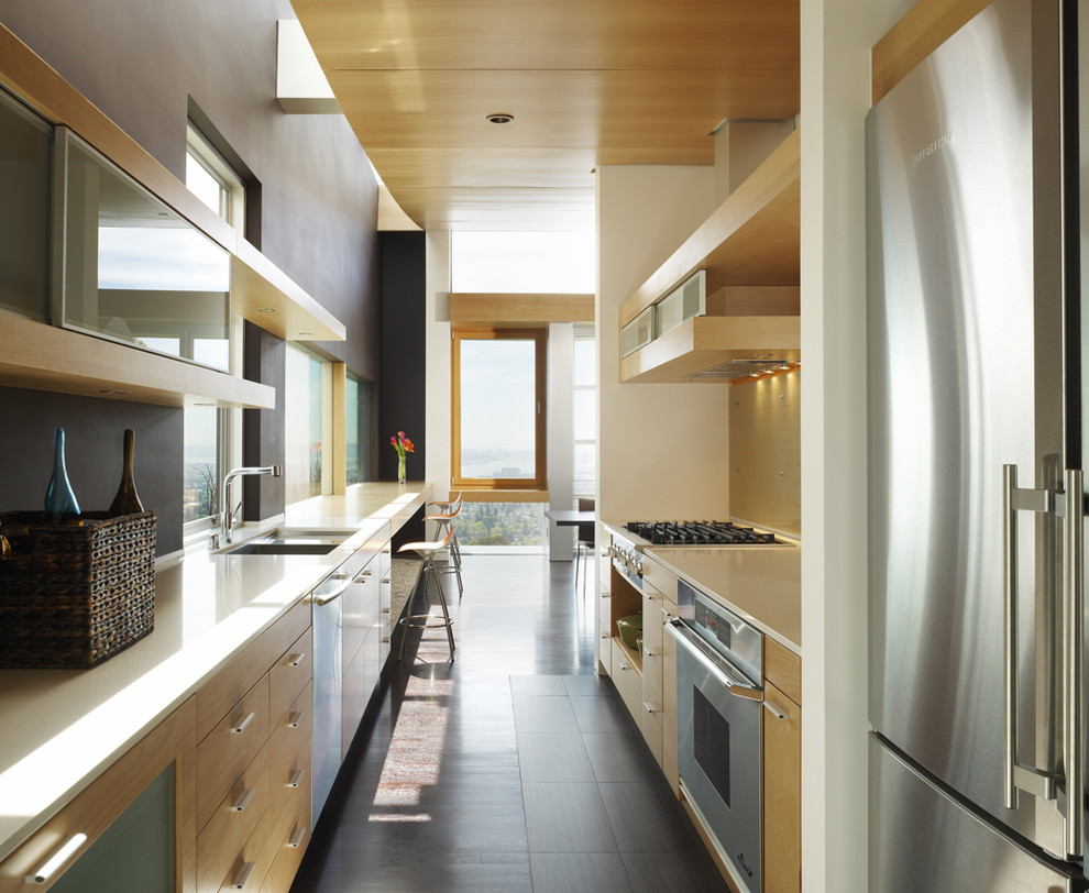 Foto di una cucina parallela contemporanea chiusa con elettrodomestici in acciaio inossidabile e ante in legno chiaro
