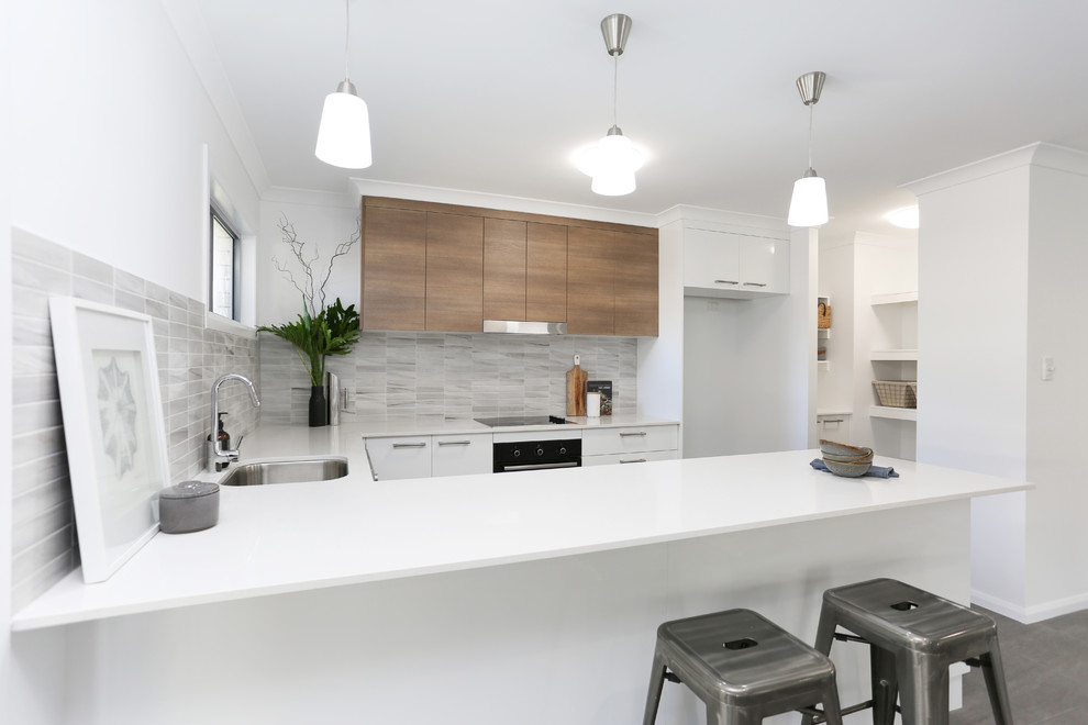 Exempel på ett litet minimalistiskt kök, med en undermonterad diskho, släta luckor, vita skåp, bänkskiva i kvarts, flerfärgad stänkskydd, stänkskydd i mosaik, rostfria vitvaror, klinkergolv i keramik, en halv köksö och grått golv