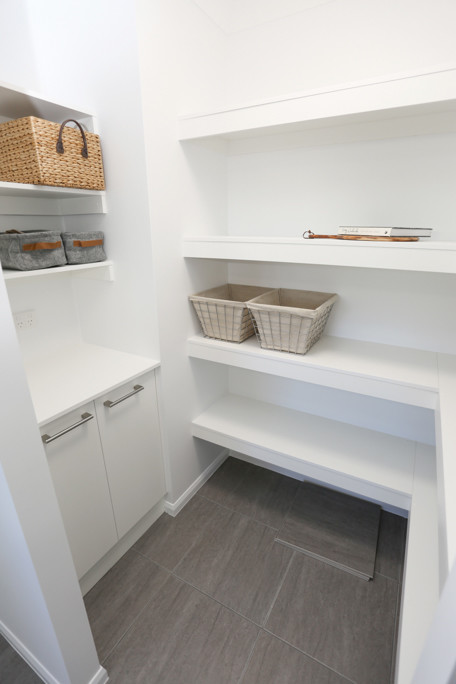 Photo of a small scandi l-shaped kitchen pantry in Other with a submerged sink, flat-panel cabinets, white cabinets, engineered stone countertops, multi-coloured splashback, mosaic tiled splashback, stainless steel appliances, ceramic flooring, a breakfast bar and grey floors.