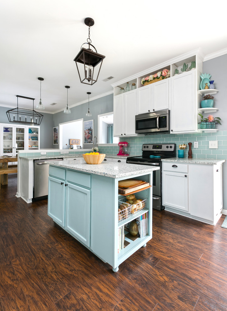 Example of a mid-sized beach style u-shaped dark wood floor and brown floor eat-in kitchen design in Charleston with shaker cabinets, recycled glass countertops, blue backsplash, ceramic backsplash, stainless steel appliances, an island, a single-bowl sink and white cabinets
