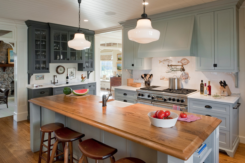 Inspiration for a large coastal u-shaped medium tone wood floor eat-in kitchen remodel in Providence with wood countertops, a farmhouse sink, shaker cabinets, gray cabinets, white backsplash, paneled appliances and an island