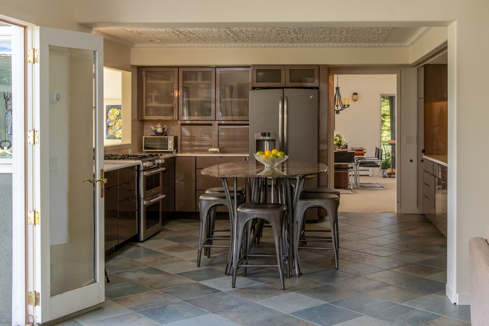 Foto di una cucina tradizionale con ante lisce, ante marroni, paraspruzzi marrone, elettrodomestici in acciaio inossidabile, pavimento grigio e top blu