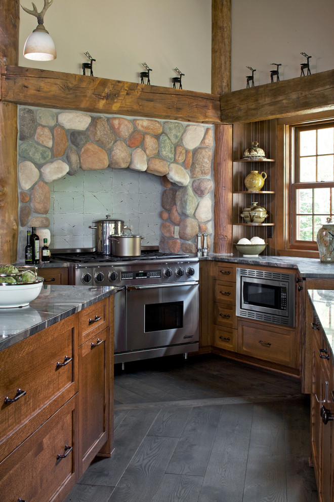 Example of a mountain style u-shaped dark wood floor and black floor kitchen design in Other with shaker cabinets, dark wood cabinets, an island and gray countertops