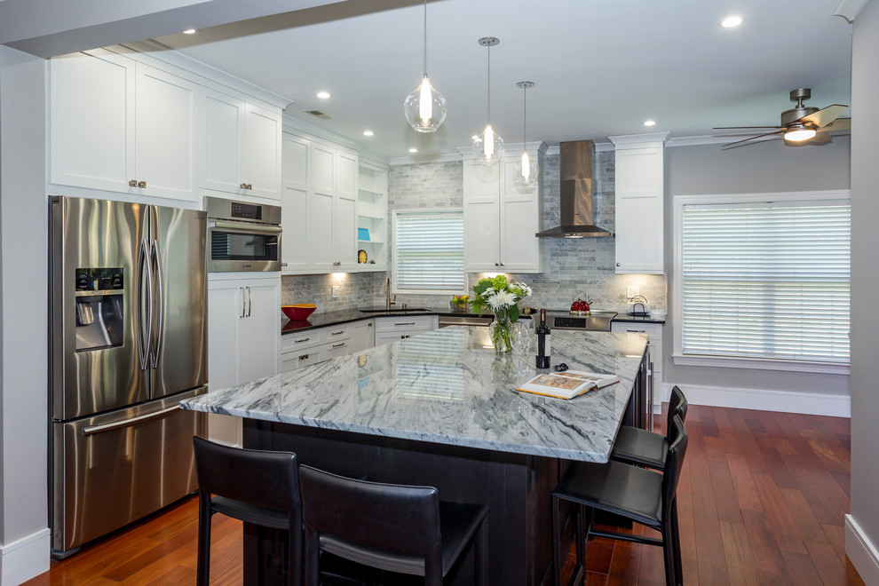 Enclosed kitchen - mid-sized contemporary l-shaped dark wood floor and brown floor enclosed kitchen idea in Charlotte with an undermount sink, shaker cabinets, white cabinets, marble countertops, gray backsplash, mosaic tile backsplash, stainless steel appliances and an island