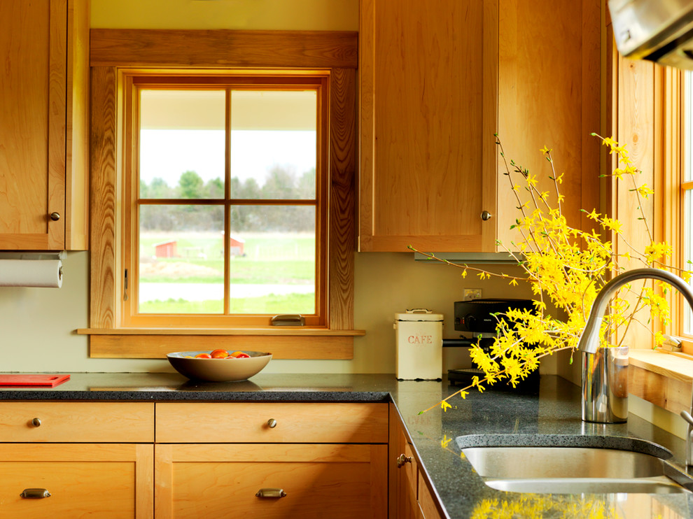Inspiration for a medium sized rural l-shaped kitchen/diner in Burlington with a double-bowl sink, shaker cabinets, light wood cabinets, recycled glass countertops, stainless steel appliances, light hardwood flooring and an island.
