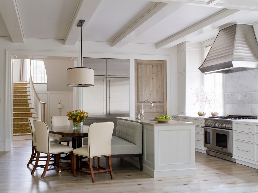 Foto di una cucina classica con ante bianche, top in marmo, paraspruzzi bianco, paraspruzzi con piastrelle in pietra, elettrodomestici in acciaio inossidabile e parquet chiaro