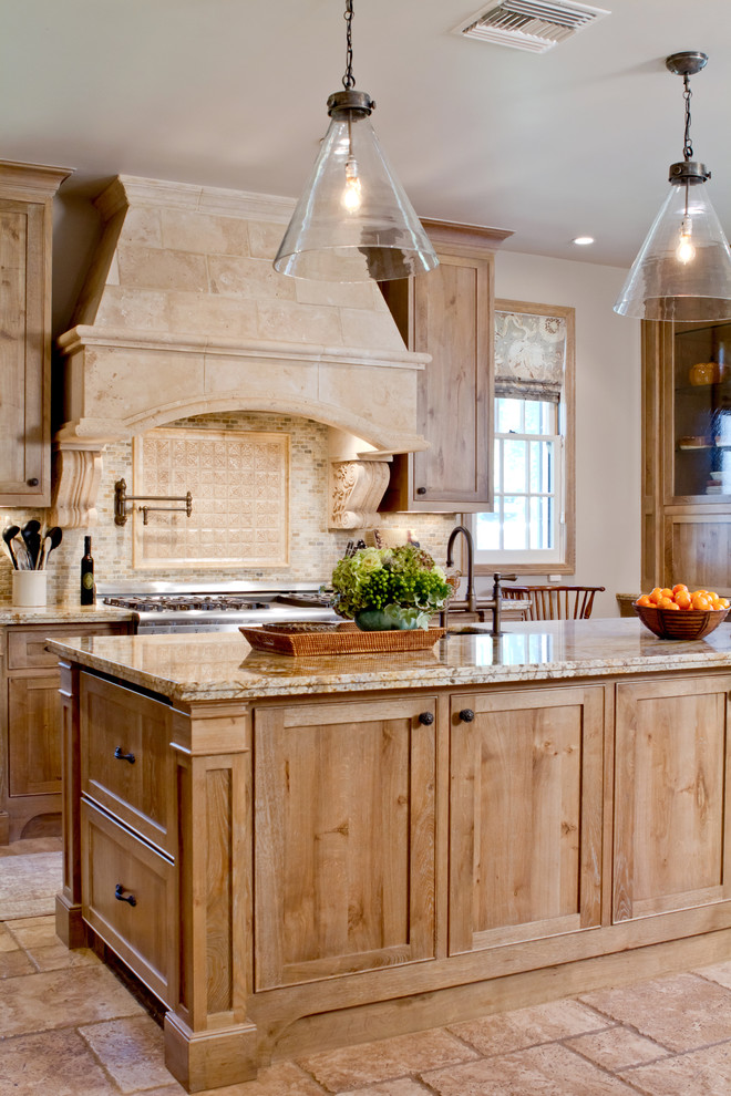 Réalisation d'une cuisine chalet en bois clair avec un plan de travail en granite et une crédence beige.