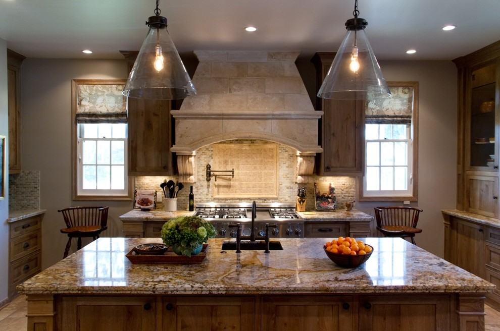 Exempel på ett klassiskt kök med öppen planlösning, med skåp i shakerstil, skåp i mellenmörkt trä, granitbänkskiva, beige stänkskydd, stänkskydd i stenkakel, rostfria vitvaror, travertin golv och en köksö