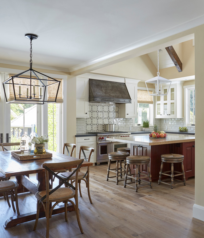 Foto på ett mellanstort lantligt flerfärgad kök, med en rustik diskho, skåp i shakerstil, vita skåp, träbänkskiva, vitt stänkskydd, stänkskydd i tunnelbanekakel, rostfria vitvaror, mellanmörkt trägolv, en köksö och brunt golv