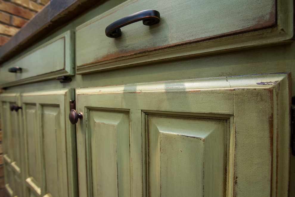 Diseño de cocina romántica de tamaño medio con armarios con paneles con relieve, puertas de armario verdes, encimera de azulejos, salpicadero marrón y salpicadero de azulejos de terracota