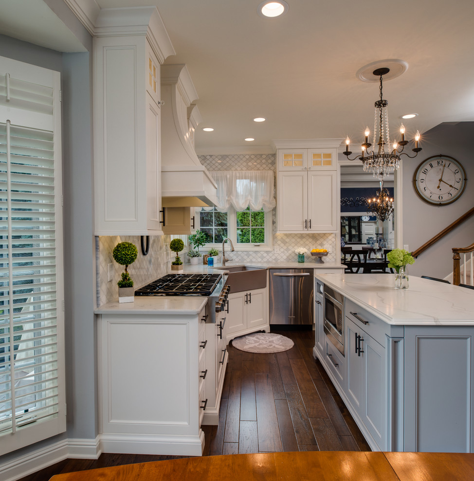 Mid-sized farmhouse l-shaped medium tone wood floor and brown floor eat-in kitchen photo in Detroit with a farmhouse sink, recessed-panel cabinets, white cabinets, quartzite countertops, gray backsplash, marble backsplash, stainless steel appliances, an island and white countertops