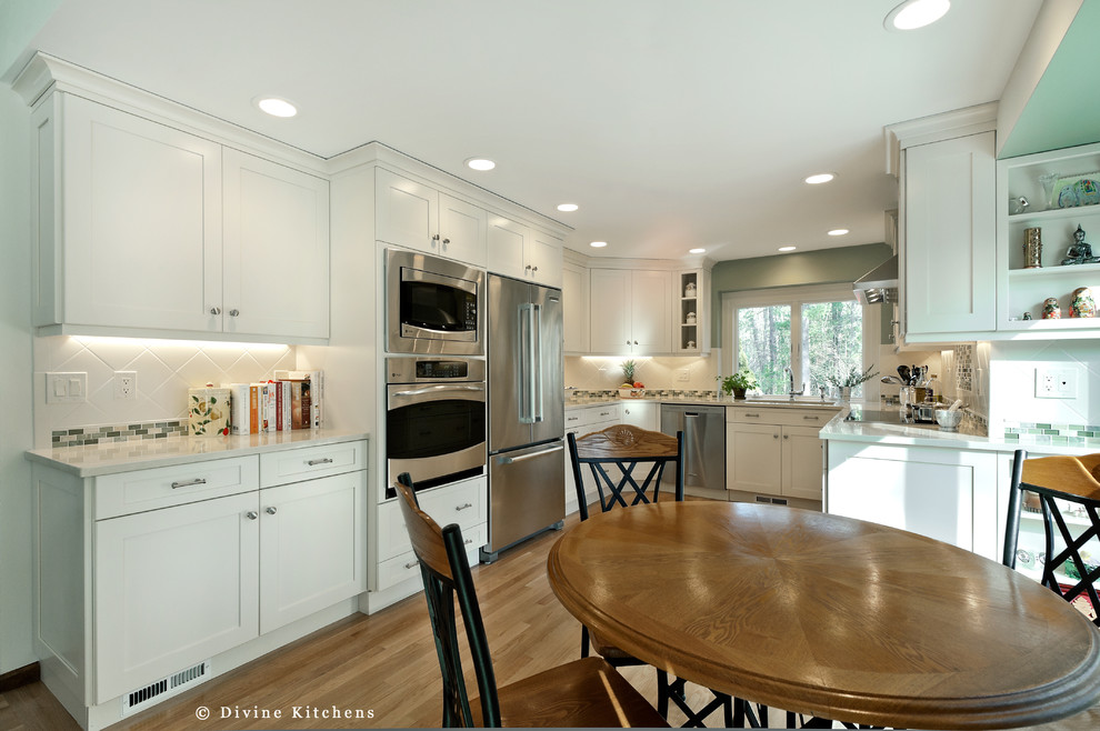 Exempel på ett stort modernt kök och matrum, med en undermonterad diskho, vitt stänkskydd, ljust trägolv och granitbänkskiva