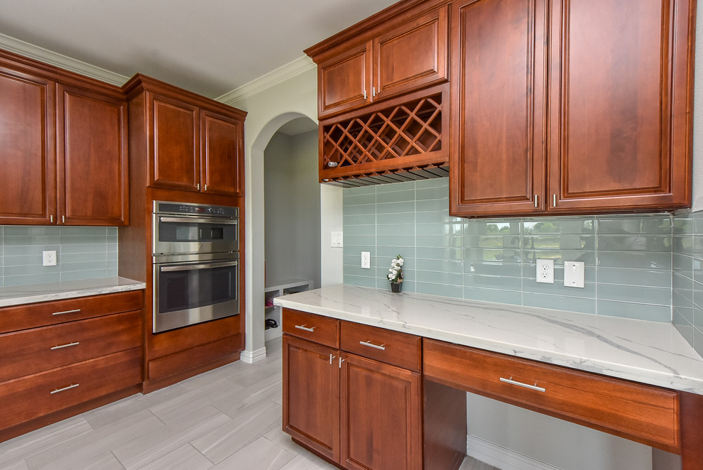 Example of a mid-sized classic l-shaped porcelain tile and gray floor eat-in kitchen design in Houston with a double-bowl sink, red cabinets, quartz countertops, blue backsplash, glass tile backsplash, stainless steel appliances, an island and white countertops