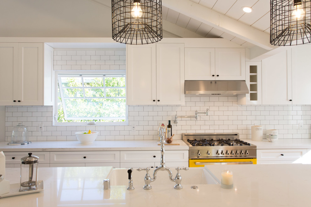 Inspiration for a mid-sized country galley kitchen remodel in Los Angeles with a farmhouse sink, white cabinets, quartz countertops, white backsplash and stainless steel appliances