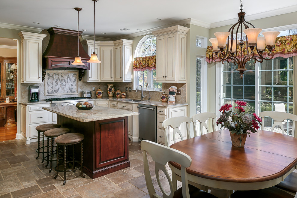 Traditional l-shaped open plan kitchen in Philadelphia with a submerged sink, raised-panel cabinets, white cabinets, beige splashback, stainless steel appliances and an island.