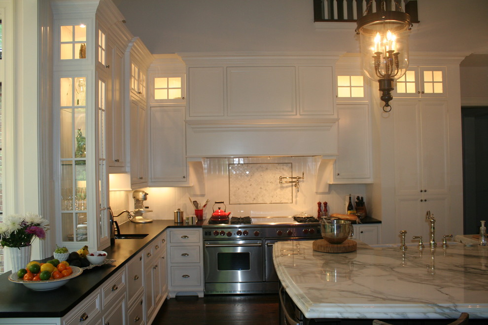 Exempel på ett klassiskt kök, med en rustik diskho, luckor med upphöjd panel, vita skåp, vitt stänkskydd, rostfria vitvaror, mörkt trägolv och en köksö