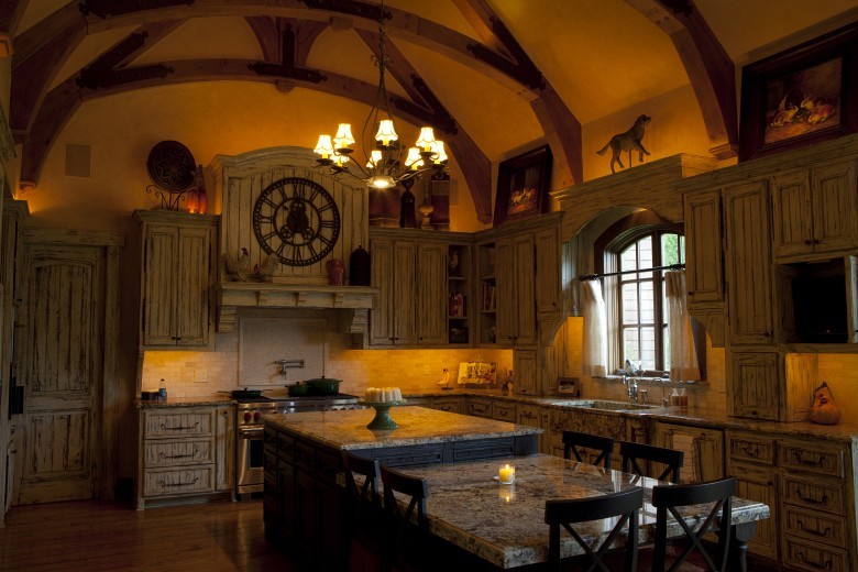 Inspiration för stora klassiska kök, med en undermonterad diskho, luckor med profilerade fronter, skåp i slitet trä, granitbänkskiva, beige stänkskydd, rostfria vitvaror, mellanmörkt trägolv och en köksö