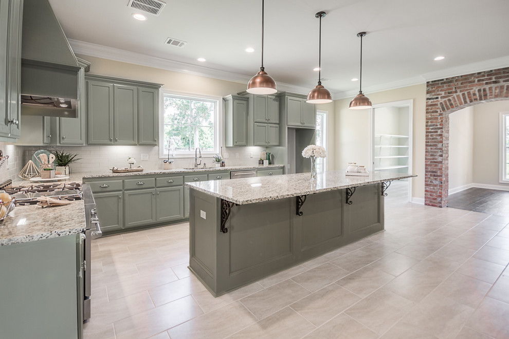 Large elegant l-shaped ceramic tile and beige floor eat-in kitchen photo in New Orleans with an undermount sink, flat-panel cabinets, green cabinets, granite countertops, beige backsplash, subway tile backsplash, stainless steel appliances, an island and white countertops