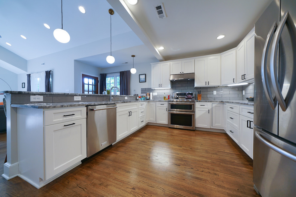 Idéer för att renovera ett mellanstort vintage vit vitt kök, med en undermonterad diskho, släta luckor, vita skåp, granitbänkskiva, grått stänkskydd, stänkskydd i keramik, rostfria vitvaror, mellanmörkt trägolv och brunt golv