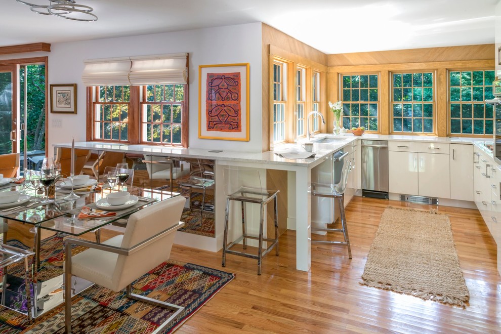 Klassische Wohnküche ohne Insel in U-Form mit Unterbauwaschbecken, flächenbündigen Schrankfronten, weißen Schränken, braunem Holzboden, braunem Boden und grauer Arbeitsplatte in Boston