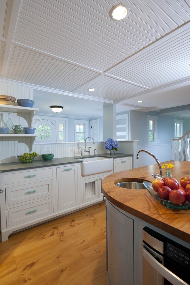 Example of an eclectic kitchen design in Newark with a farmhouse sink and wood countertops