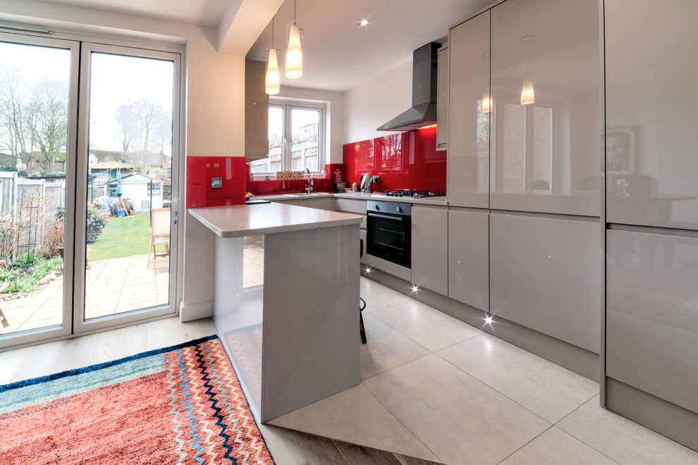 Zweizeilige, Mittelgroße Moderne Wohnküche mit flächenbündigen Schrankfronten, roten Schränken, Granit-Arbeitsplatte und Kücheninsel in London