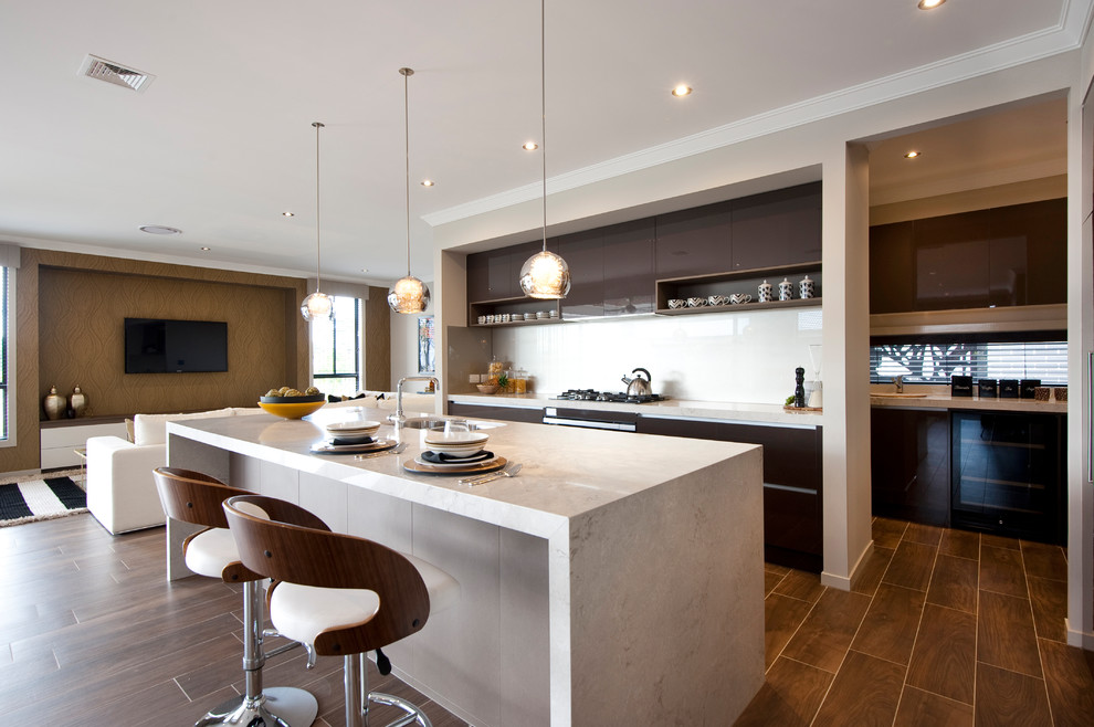Exempel på ett modernt kök, med släta luckor, bruna skåp, vitt stänkskydd, klinkergolv i porslin och en köksö