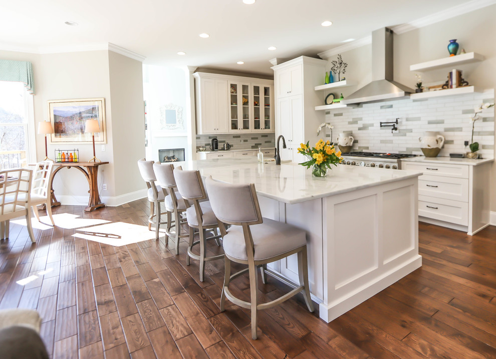 Modern inredning av ett mellanstort vit linjärt vitt kök och matrum, med en rustik diskho, skåp i shakerstil, vita skåp, marmorbänkskiva, vitt stänkskydd, stänkskydd i tunnelbanekakel, vita vitvaror, mörkt trägolv, en köksö och brunt golv