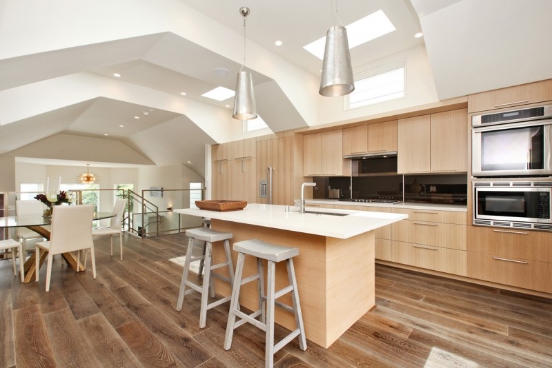 Example of a mid-sized trendy u-shaped porcelain tile and brown floor eat-in kitchen design in San Francisco with an undermount sink, flat-panel cabinets, light wood cabinets, quartz countertops, black backsplash, stone slab backsplash, paneled appliances, an island and white countertops
