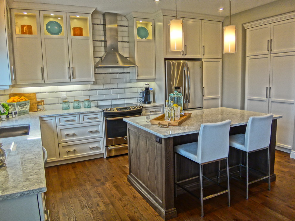 Foto di una cucina chic con lavello sottopiano, top in quarzite, paraspruzzi bianco, elettrodomestici in acciaio inossidabile e pavimento in legno massello medio