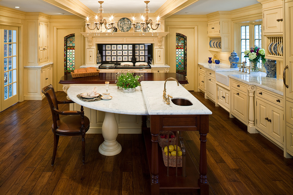 Esempio di una cucina classica con lavello stile country, top in marmo, ante con bugna sagomata e ante gialle