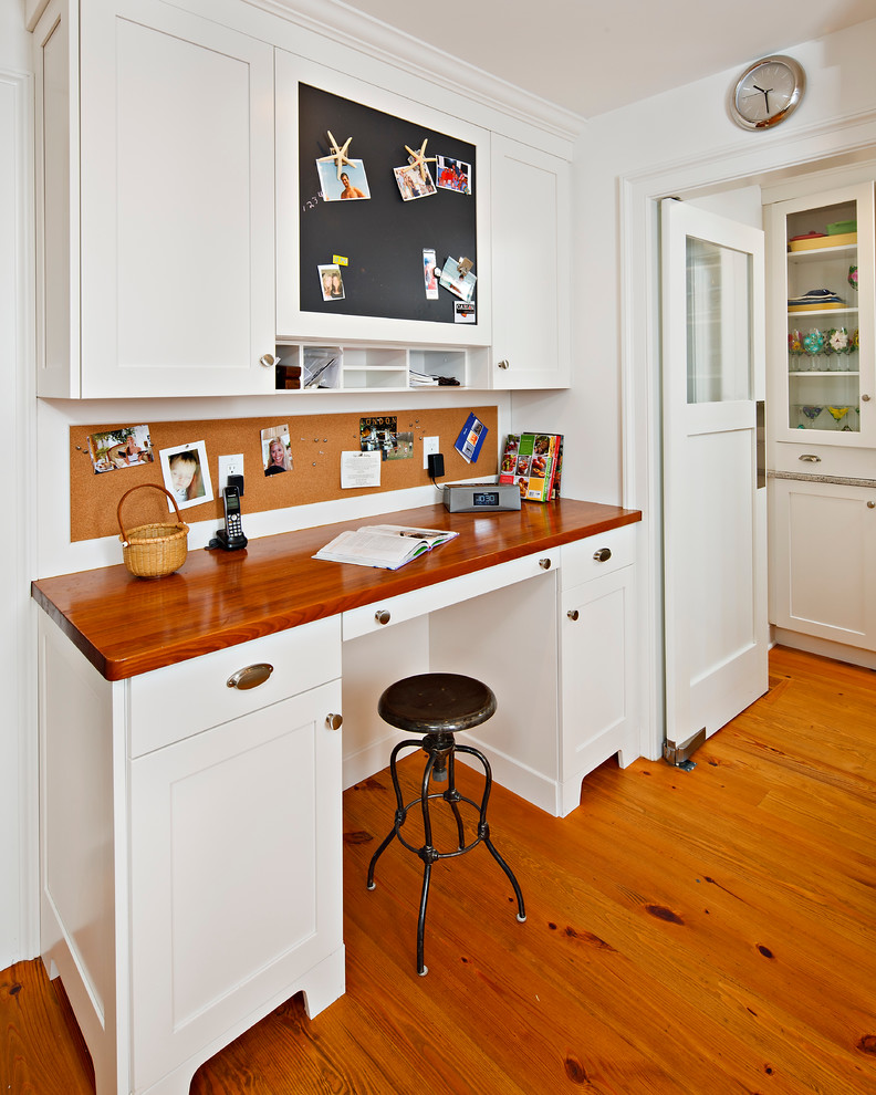 Bild på ett vintage skafferi, med luckor med infälld panel, vita skåp, en undermonterad diskho och en köksö