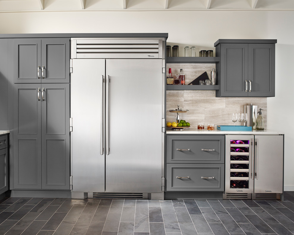 Exempel på ett avskilt, mellanstort klassiskt l-kök, med en undermonterad diskho, luckor med infälld panel, grå skåp, granitbänkskiva, beige stänkskydd, stänkskydd i porslinskakel, rostfria vitvaror, klinkergolv i keramik, en köksö och grått golv