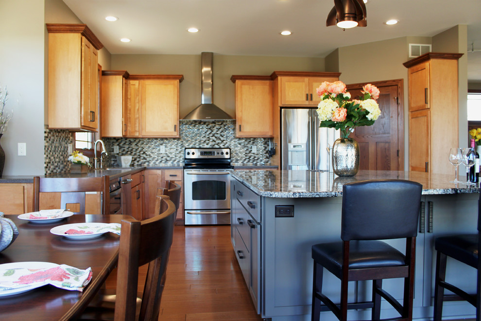 Bild på ett stort funkis kök, med en dubbel diskho, skåp i shakerstil, skåp i mellenmörkt trä, granitbänkskiva, flerfärgad stänkskydd, stänkskydd i stenkakel, rostfria vitvaror, mellanmörkt trägolv och en köksö