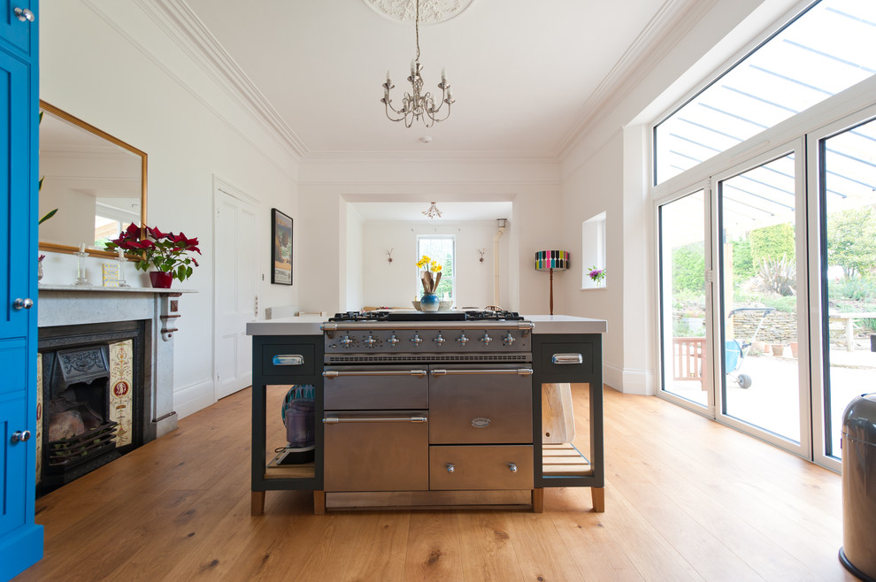 Geräumige Moderne Wohnküche mit blauen Schränken, Quarzwerkstein-Arbeitsplatte, Küchengeräten aus Edelstahl und hellem Holzboden in Cornwall