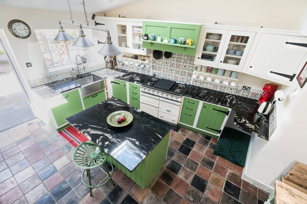 Inredning av ett lantligt litet svart svart kök, med en rustik diskho, gröna skåp, granitbänkskiva, flerfärgad stänkskydd, stänkskydd i mosaik, integrerade vitvaror, klinkergolv i porslin, en köksö och flerfärgat golv