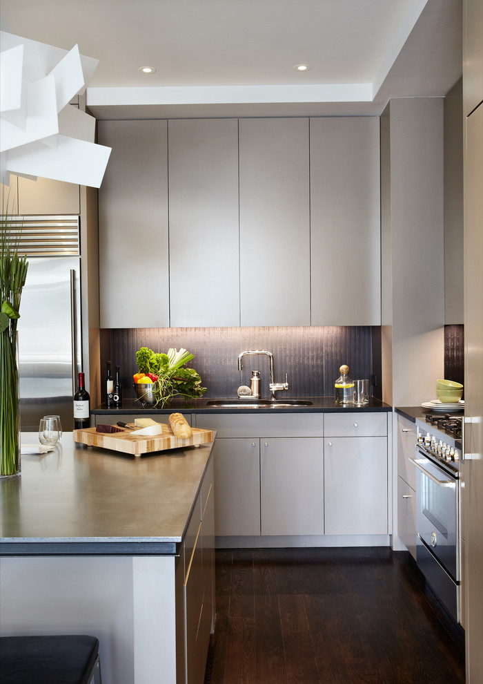 Contemporary kitchen in New York with flat-panel cabinets, grey cabinets and stainless steel appliances.